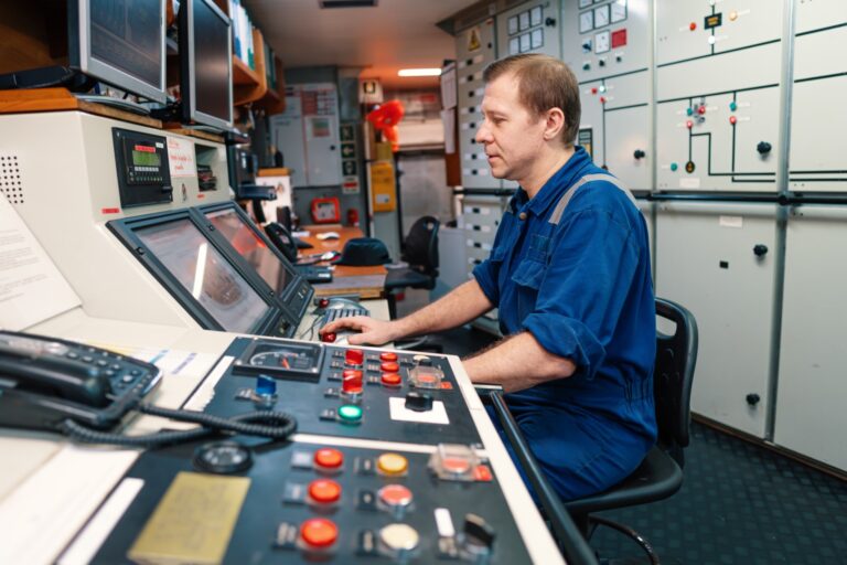 Marine engineer at the console in a ship's engine control room