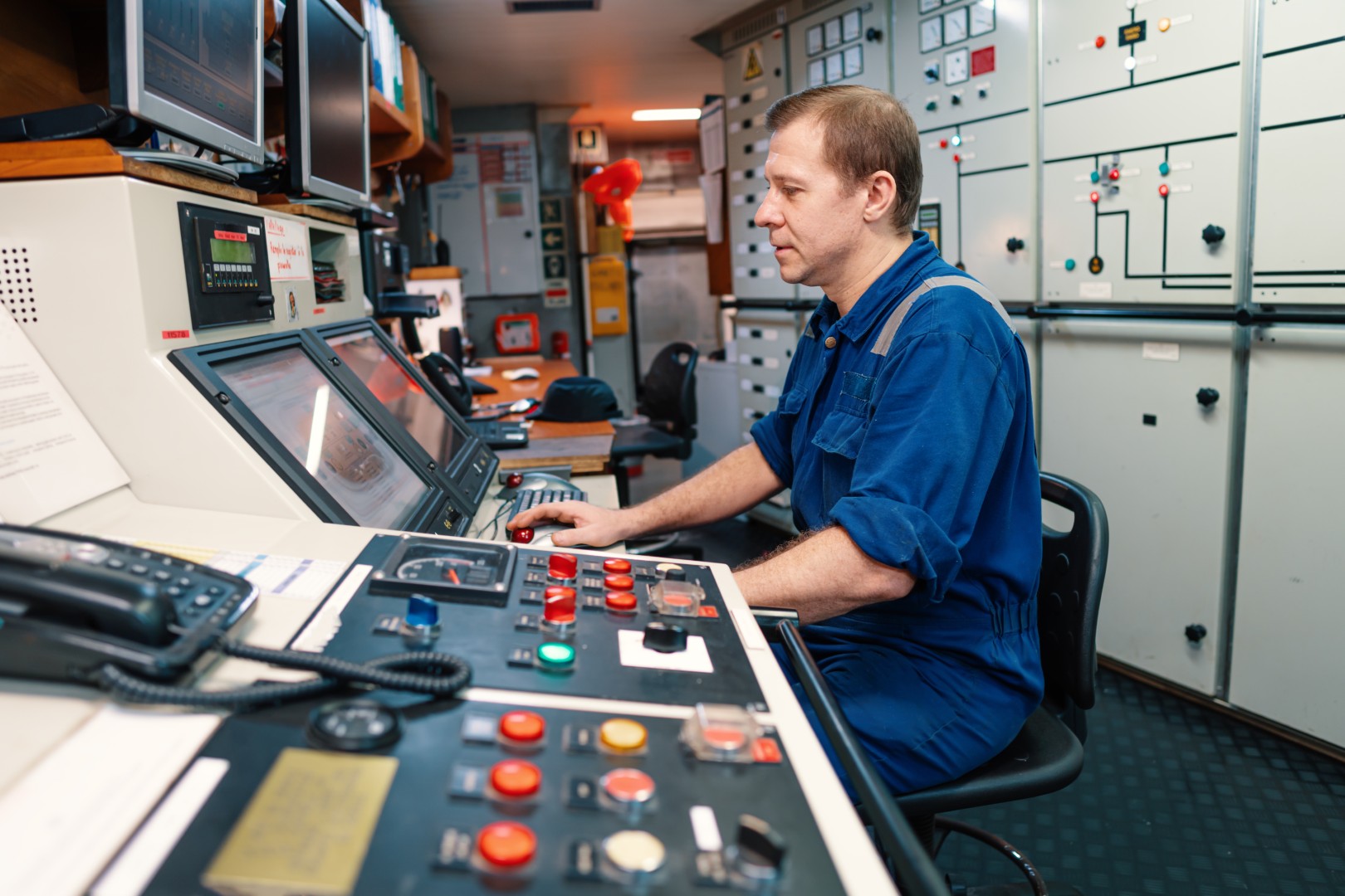 Marine engineer at the console in a ship's engine control room