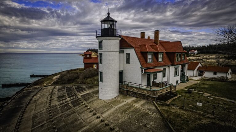 White lighthouse and red-roofed keeper's house on a lakeshore